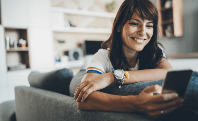 Woman checking her phone on a couch.