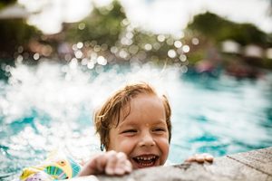 child splashing in pool