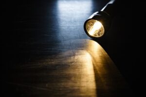 flashlight on a hard wood floor in a dark room